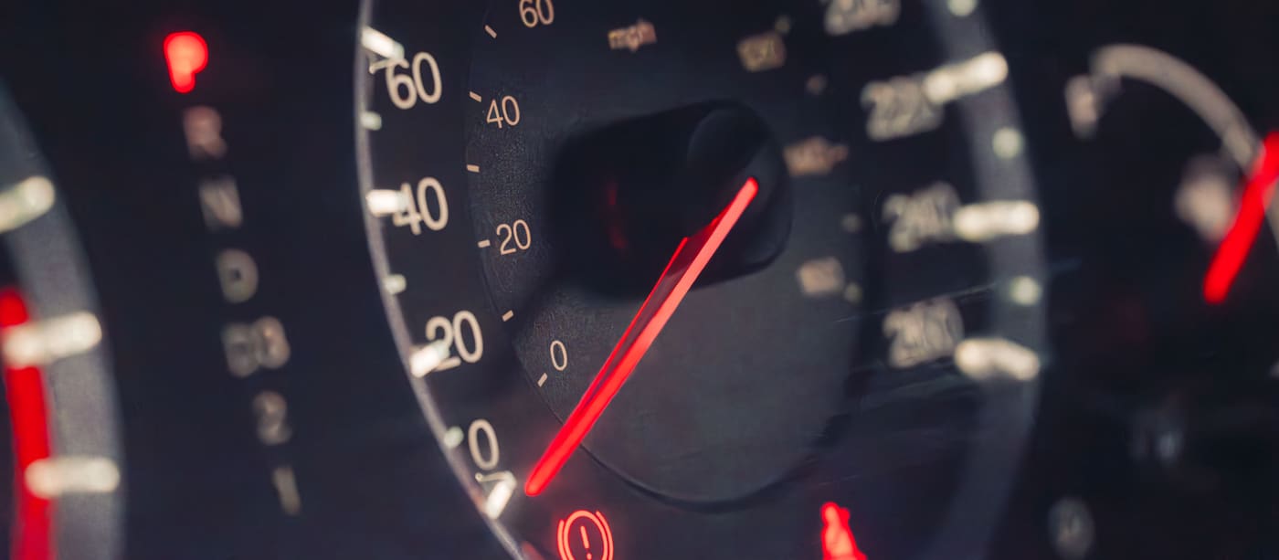 Close-up of a car instrument cluster showing the speedometer in kilometres and miles per hour.